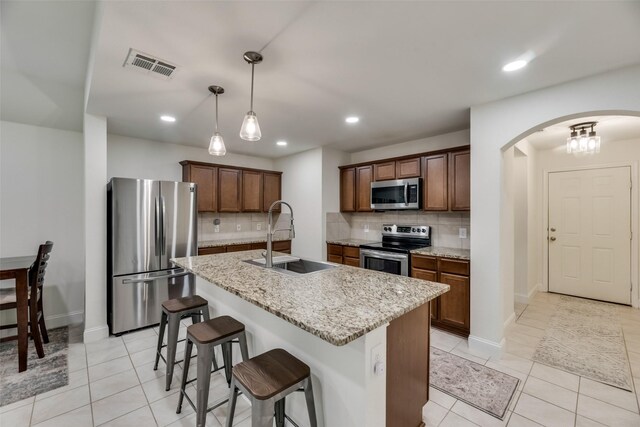 2282 Torch Lake Dr, Forney, TX 75126 - kitchen featuring stainless steel appliances, a sink, arched walkways, an island with sink, and visible vents