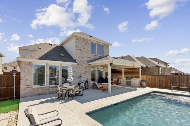 16509 Hidden Cove Dr, Celina, TX 75009 - rear view of house featuring brick siding, a patio area, a fenced backyard, and exterior kitchen