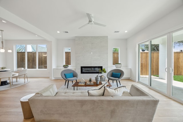 living area with recessed lighting, visible vents, ceiling fan, and a tiled fireplace