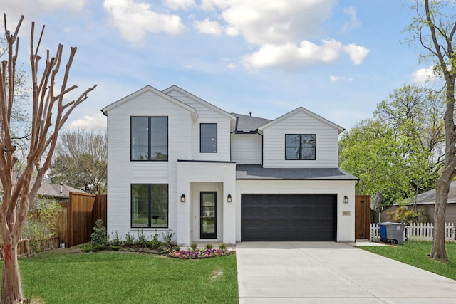 modern farmhouse with driveway, fence, a front yard, and an attached garage