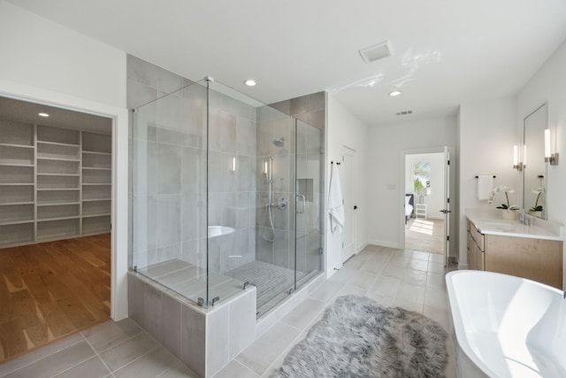 full bath with a shower stall, a soaking tub, recessed lighting, tile patterned floors, and vanity
