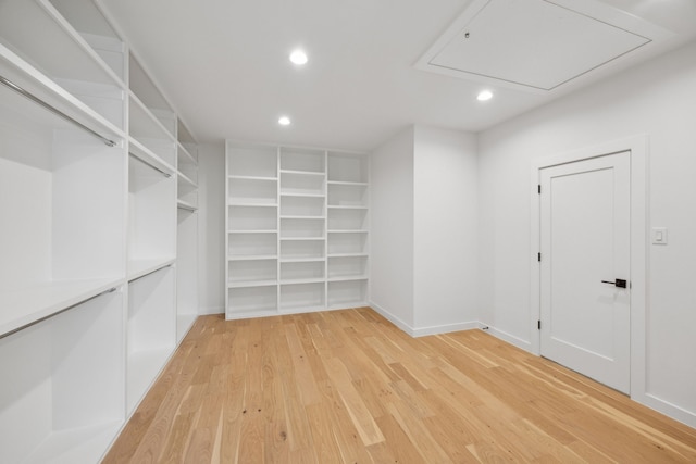 spacious closet featuring attic access and light wood-style floors