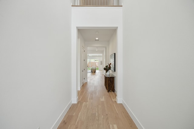 hallway with baseboards and light wood-style flooring