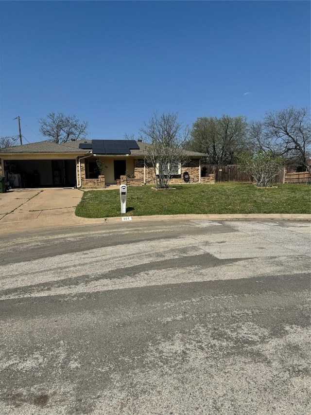 901 Freestone Ct, Arlington, TX 76017 - view of front of property with a front yard, concrete driveway, fence, solar panels, and a carport