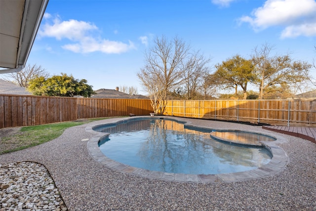 view of pool featuring a fenced backyard and a pool with connected hot tub