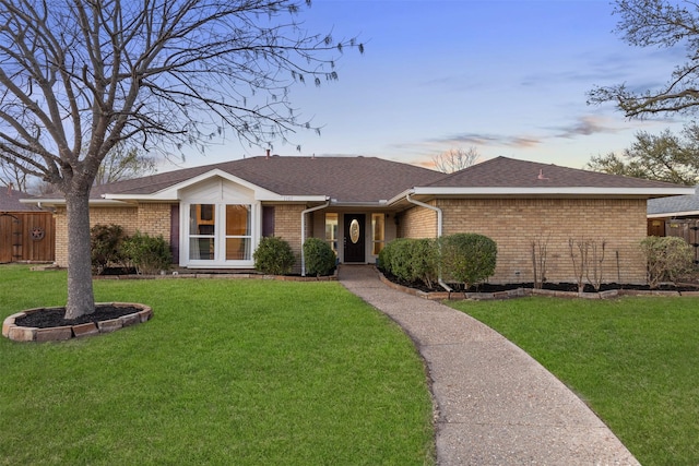 ranch-style home with brick siding and a shingled roof