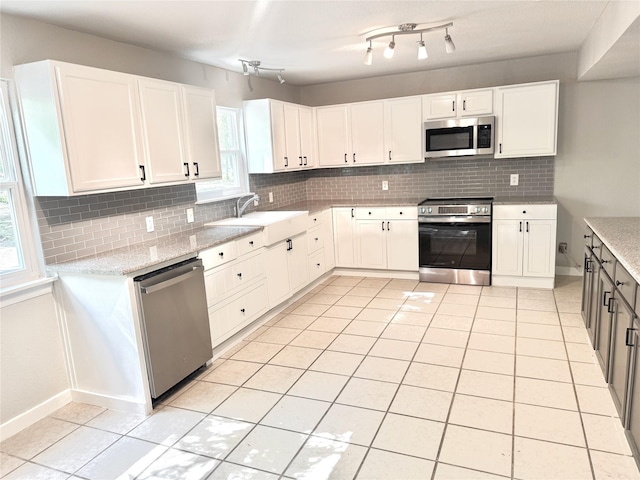 kitchen with a sink, tasteful backsplash, appliances with stainless steel finishes, and white cabinets