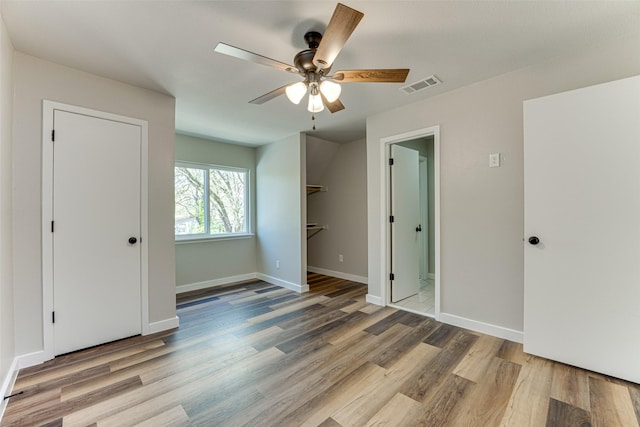 unfurnished bedroom with visible vents, baseboards, ceiling fan, and wood finished floors