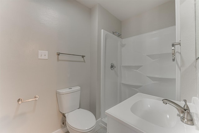 bathroom with toilet, a sink, walk in shower, tile patterned floors, and baseboards