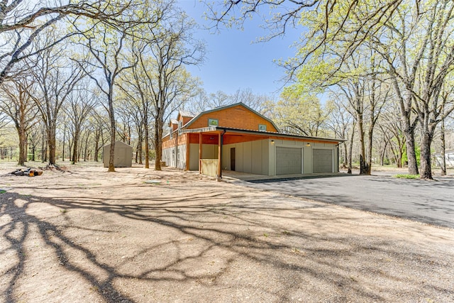 exterior space with driveway and a shed
