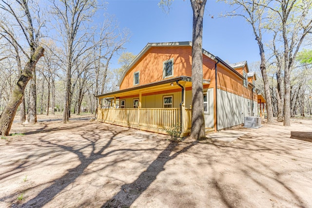 view of front of house featuring central AC, a porch, and a gambrel roof