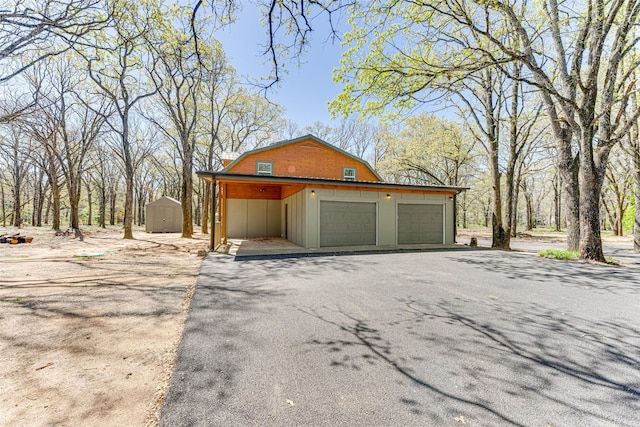 garage featuring driveway and a storage unit