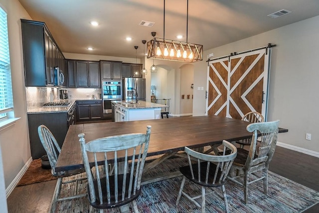 201 Virginia Ln, Hickory Creek, TX 75065 - dining space with dark wood-style flooring, arched walkways, recessed lighting, and a barn door
