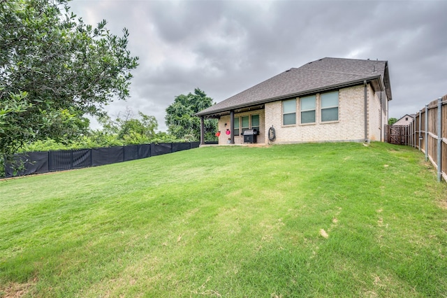 201 Virginia Ln, Hickory Creek, TX 75065 - back of house with a fenced backyard, brick siding, and a shingled roof
