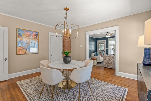 dining area featuring baseboards, wood finished floors, and an inviting chandelier