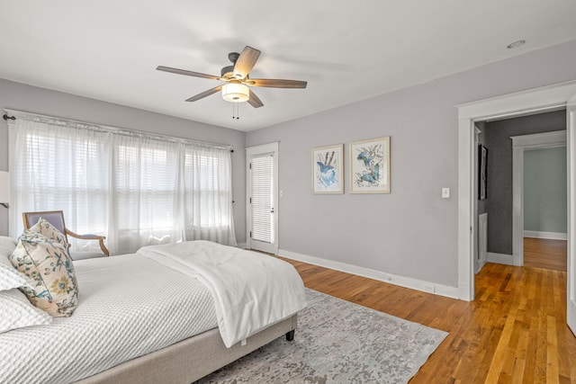 bedroom featuring baseboards, light wood-type flooring, and a ceiling fan