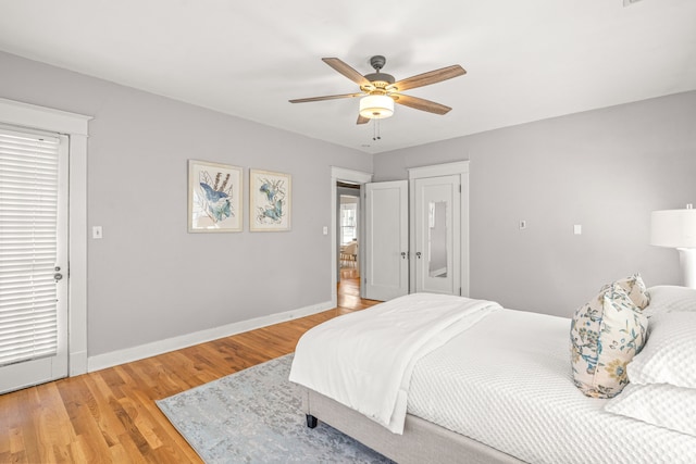 bedroom with light wood finished floors, baseboards, and a ceiling fan