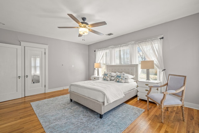bedroom featuring multiple windows, light wood-type flooring, visible vents, and baseboards