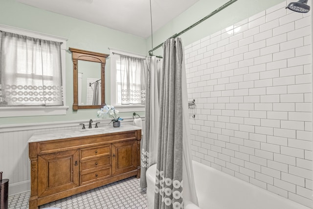 full bath featuring shower / bathtub combination with curtain, toilet, vanity, and wainscoting