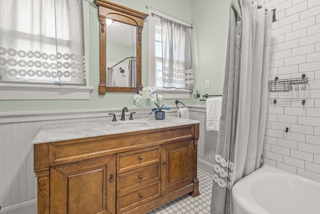 full bath with vanity, shower / bath combo, and wainscoting