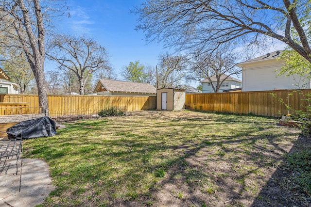 view of yard featuring a fenced backyard, an outdoor structure, and a storage shed