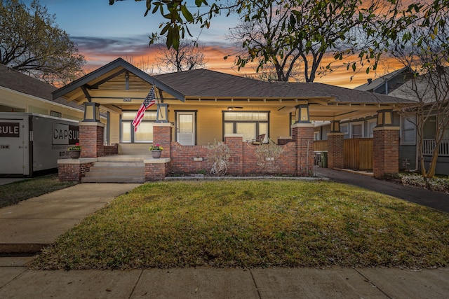 bungalow-style house with a lawn and brick siding