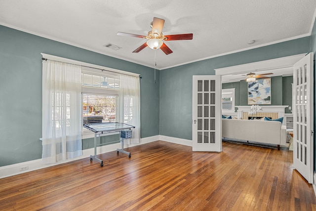 home office with visible vents, ceiling fan, french doors, and wood-type flooring
