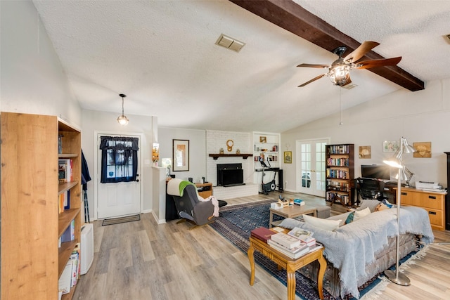living room featuring light wood-type flooring, french doors, a textured ceiling, visible vents, and vaulted ceiling with beams