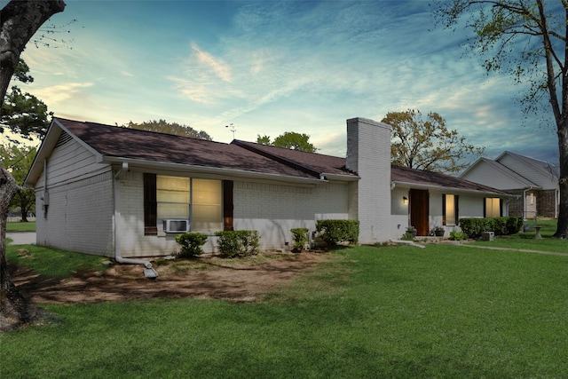 ranch-style home with cooling unit, a chimney, a front lawn, and brick siding