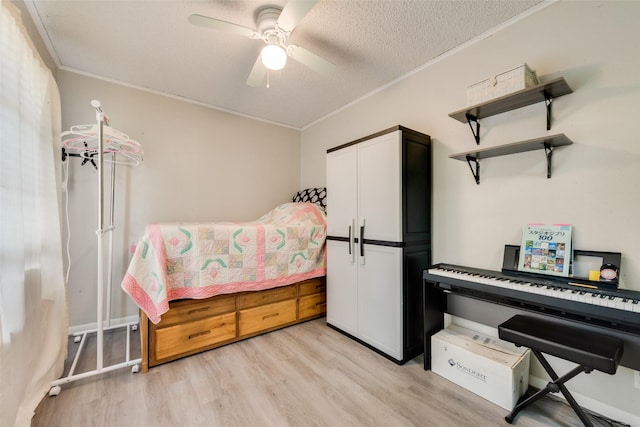 bedroom featuring a closet, a ceiling fan, light wood-style floors, a textured ceiling, and crown molding