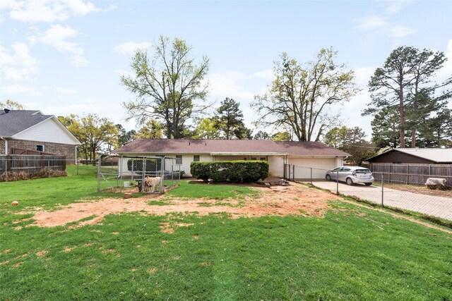 exterior space with a yard, fence, a gate, and concrete driveway