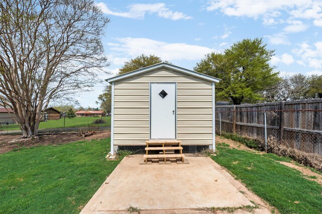 view of outbuilding with entry steps, a fenced backyard, and an outdoor structure