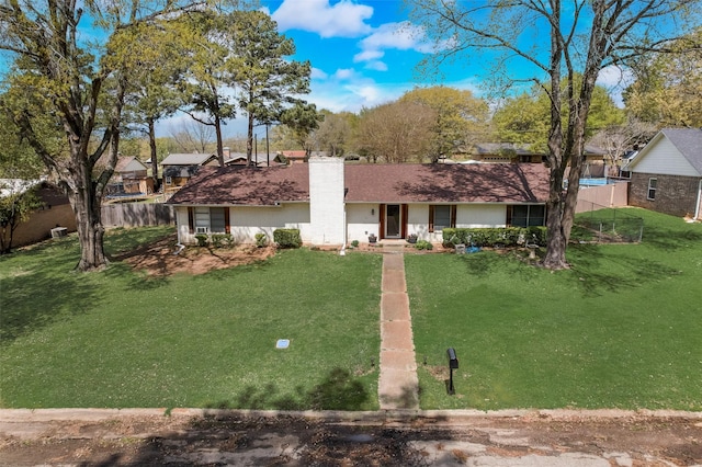 ranch-style home featuring a chimney, fence, and a front lawn