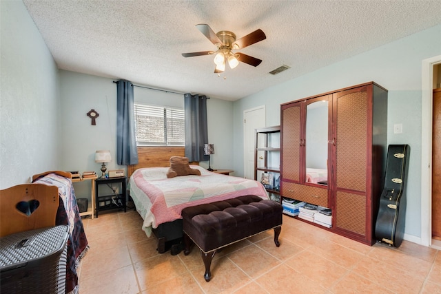 bedroom with visible vents, ceiling fan, and a textured ceiling