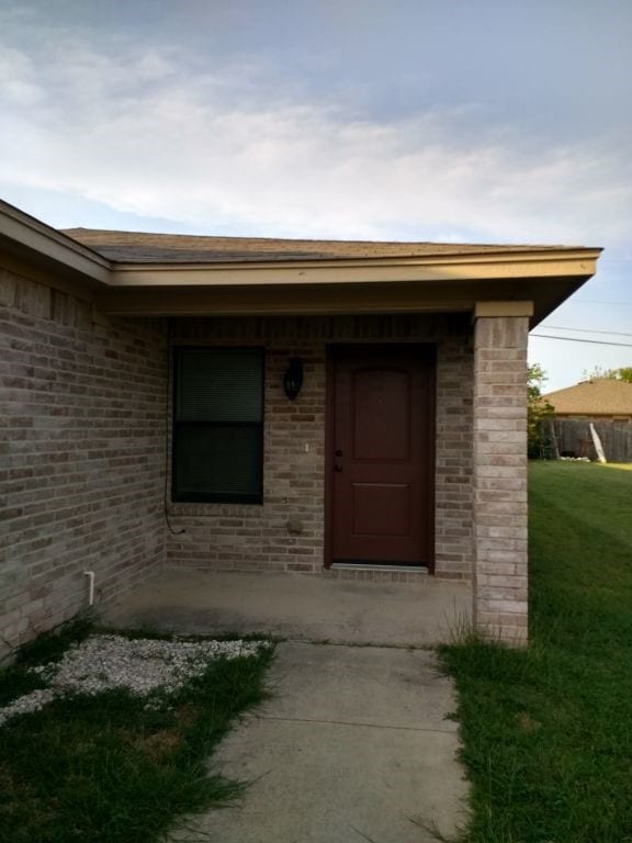 8124 Doreen Ave, Fort Worth, TX 76116 - doorway to property featuring brick siding and a yard
