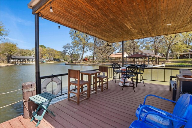 view of dock featuring a gazebo, outdoor dry bar, and a deck with water view