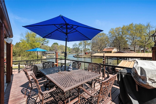 wooden deck with outdoor dining space and a water view