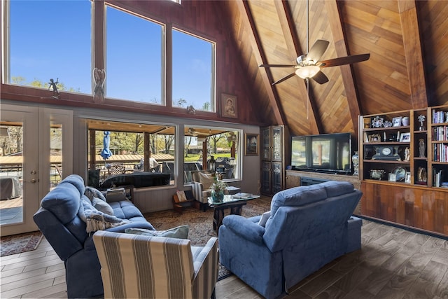 living area featuring wooden walls, wood finished floors, a ceiling fan, and high vaulted ceiling