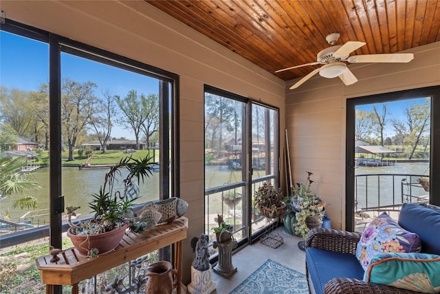 sunroom / solarium featuring a water view and ceiling fan
