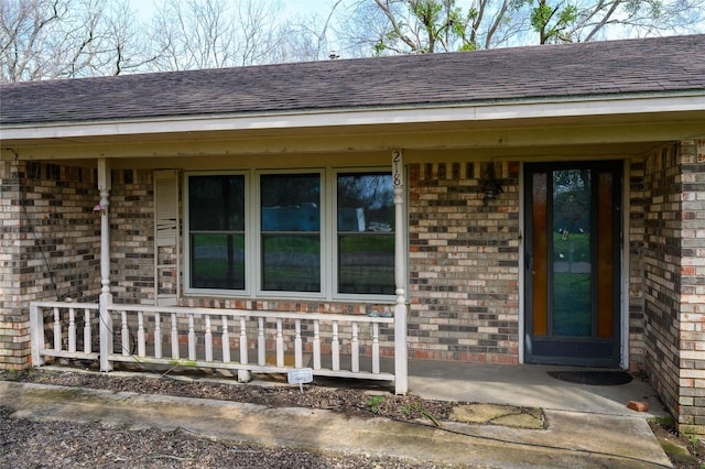 210AND218 N Collins, Colbert, OK 74733 - property entrance with a shingled roof, a porch, and brick siding