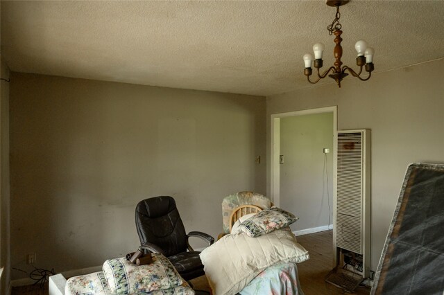 210AND218 N Collins, Colbert, OK 74733 - interior space with a textured ceiling, wood finished floors, an inviting chandelier, and a heating unit