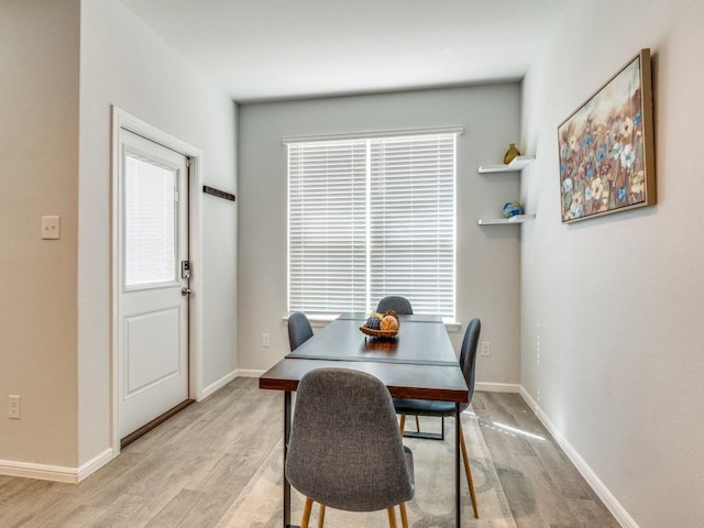 dining area featuring a wealth of natural light, baseboards, and light wood-type flooring