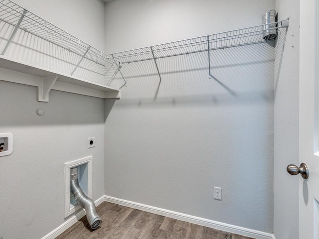 laundry area featuring hookup for a washing machine, baseboards, wood finished floors, laundry area, and electric dryer hookup