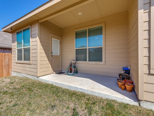 entrance to property featuring a patio and fence