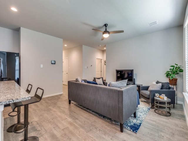 living room with baseboards, recessed lighting, light wood-style floors, and a ceiling fan