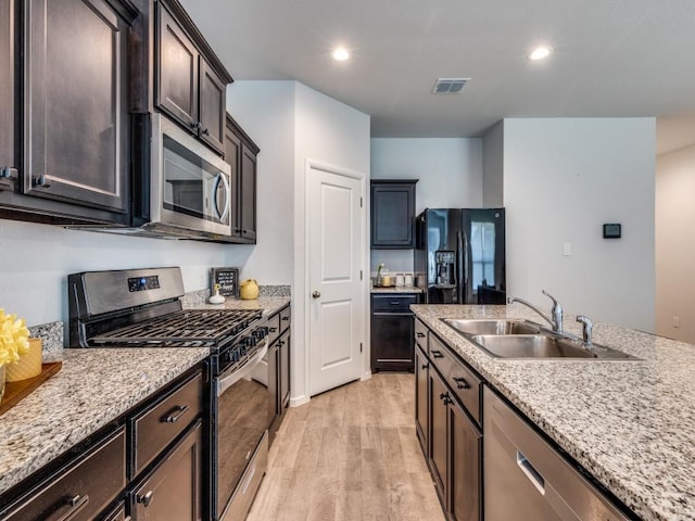 kitchen featuring visible vents, light wood finished floors, stainless steel appliances, recessed lighting, and a sink