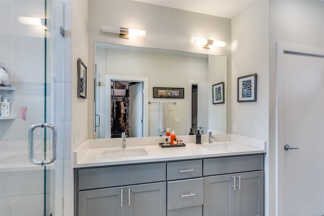 full bathroom with double vanity, a stall shower, and a sink