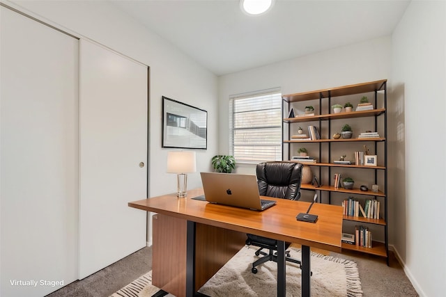 carpeted office featuring baseboards