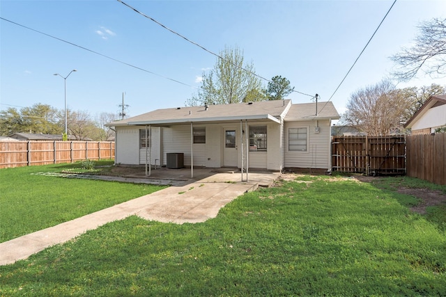 back of property featuring a lawn, a patio area, central AC, and a fenced backyard