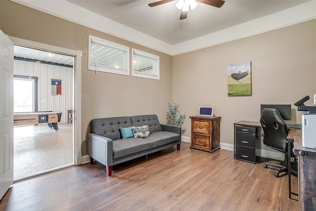 office space featuring a ceiling fan, baseboards, and light wood finished floors